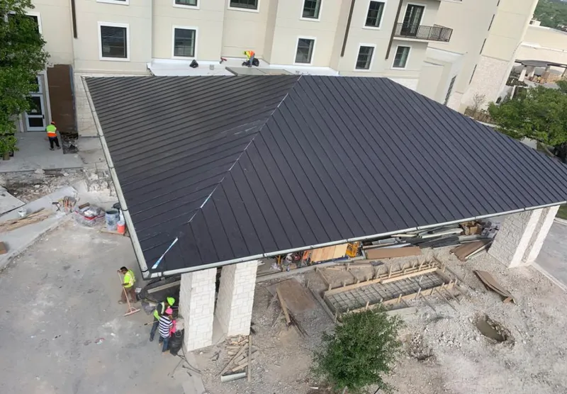 Metal roofing installation team working on a commercial building in Reedley